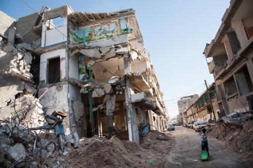 A child passes a bombed-out residential block in the Al-Zeitoun neighborhood of Gaza City. Shutterstock.com / Ryan Rodrick Beiler A child passes a bombed-out residential block in the Al-Zeitoun neighborhood of Gaza City.