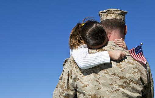 A military man hugs his child.